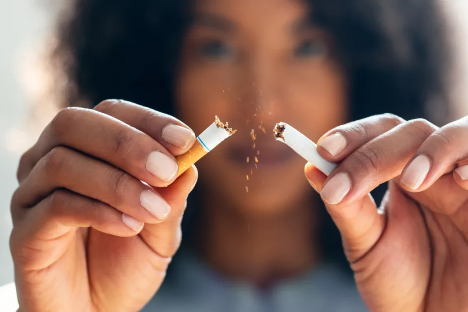 Uma pessoa parte um cigarro ao meio, espalhando pedaços de tabaco.